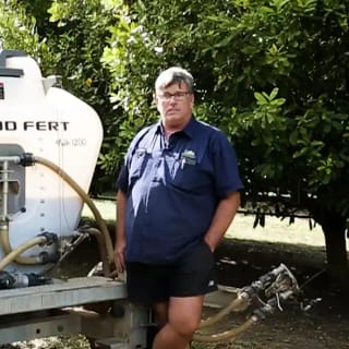 Dave Shackson, farm manager, stands with his Tow and Fert Multi 1200 in the Macadamia Orchard he manages.